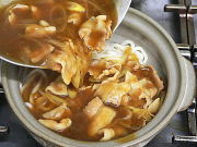 ご飯の上に麺、麺の上に更に、カレー南蛮の汁をかけ土鍋に火をつけます。 ご飯の上に麺、麺の上に更に、カレー南蛮の汁をかけ土鍋に火をつけます。